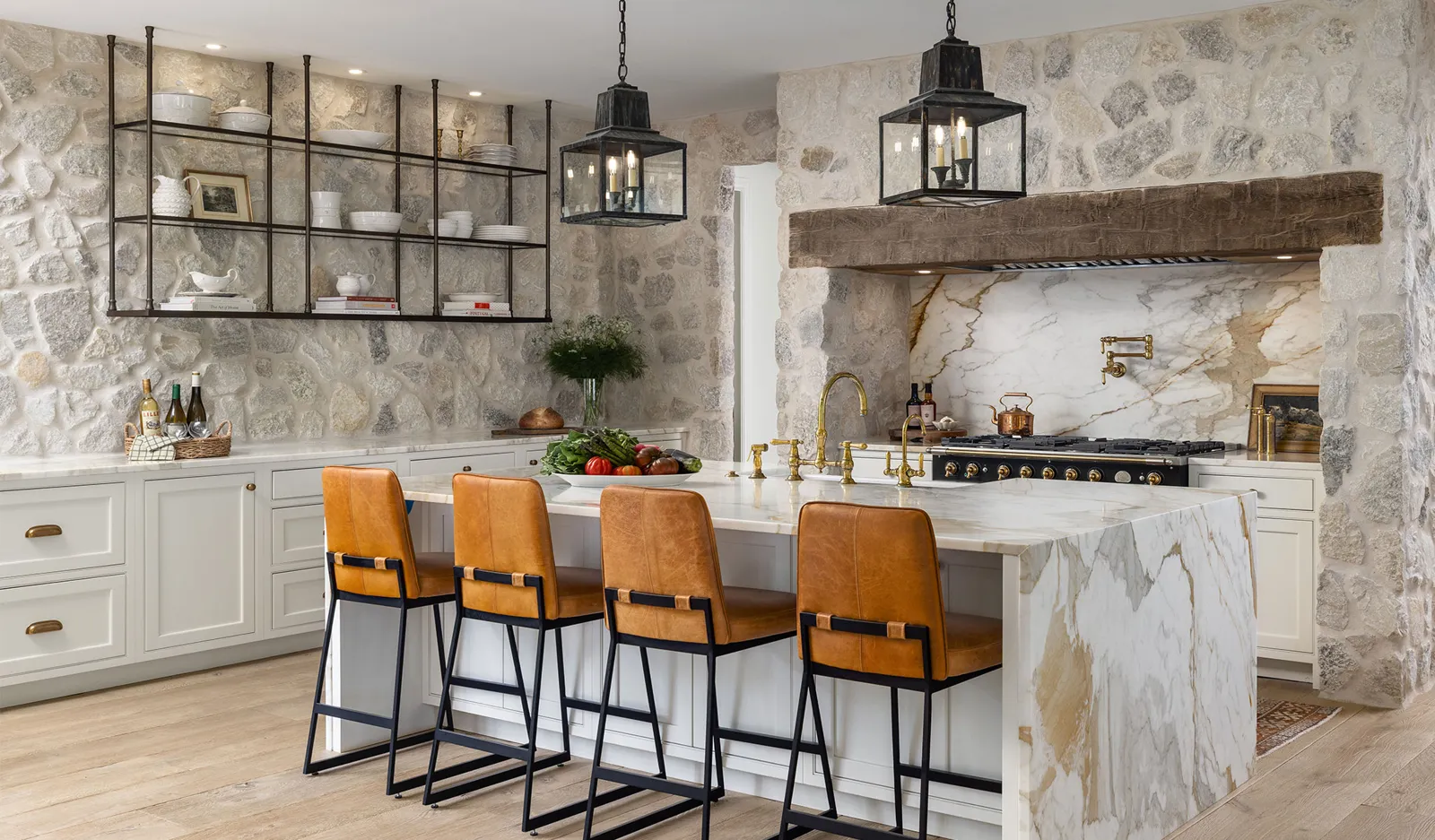 Mouser kitchen with painted cabinetry, stone walls, and leather counter stools