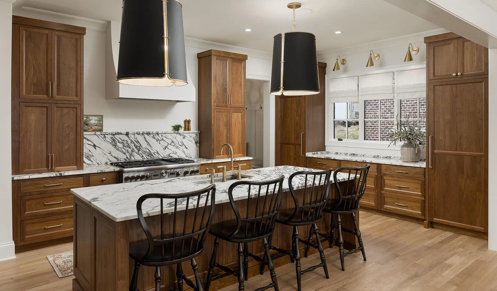 Mouser kitchen with stained walnut-tone cabinetry, tall pantry units, and a large island