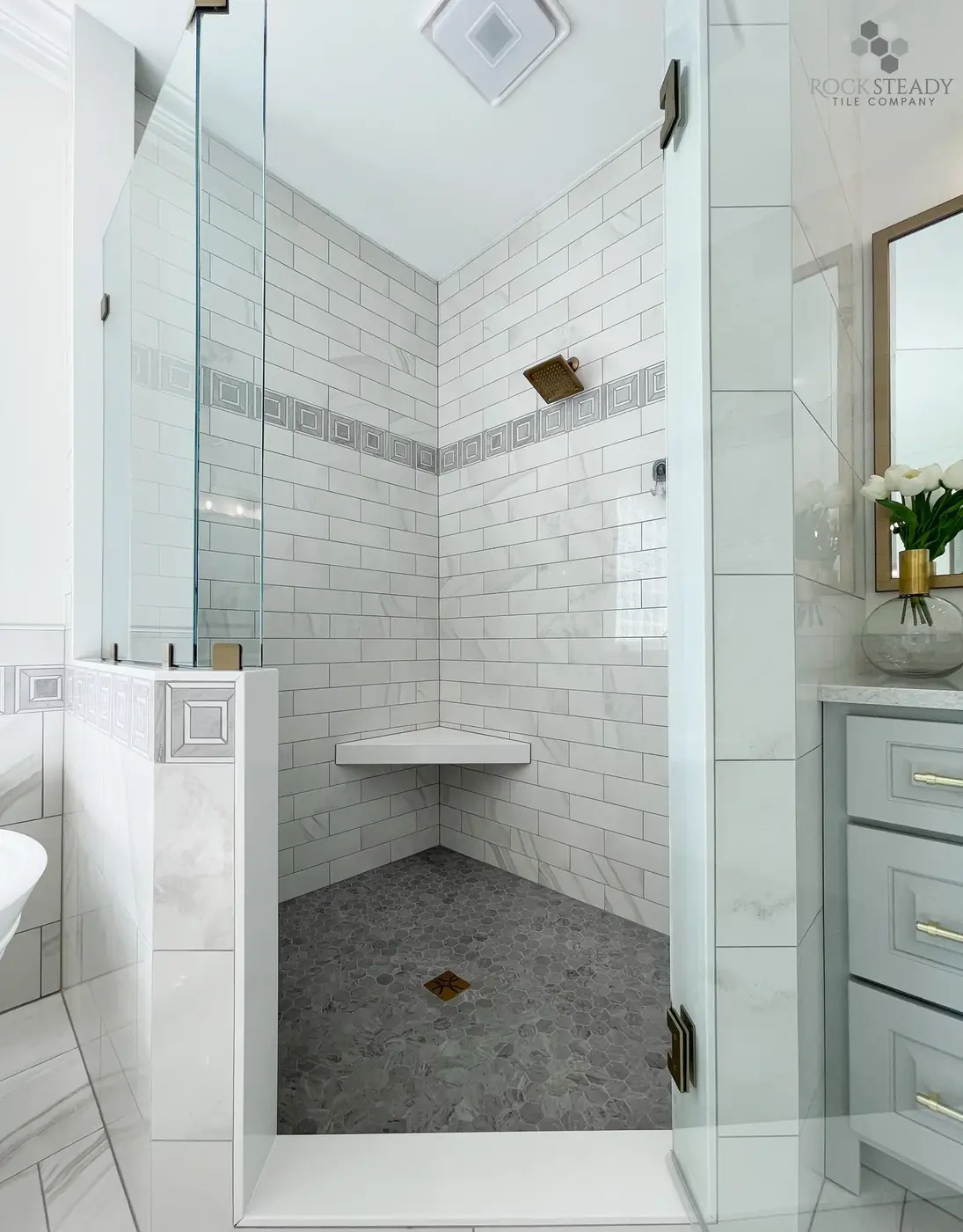 Walk-in shower with light wall tile and pebble shower floor