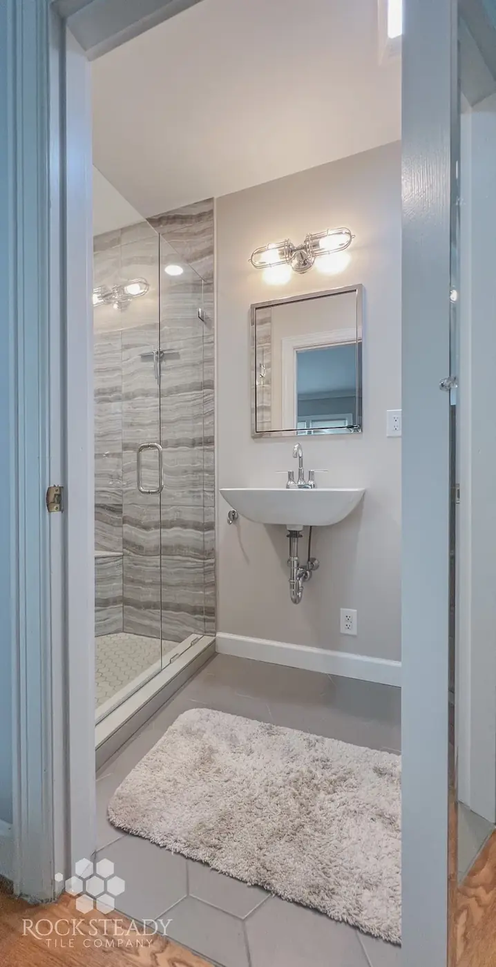 Small finished bathroom with wall tile and pedestal sink